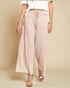 Person wearing beige wide-leg pants on a beige background