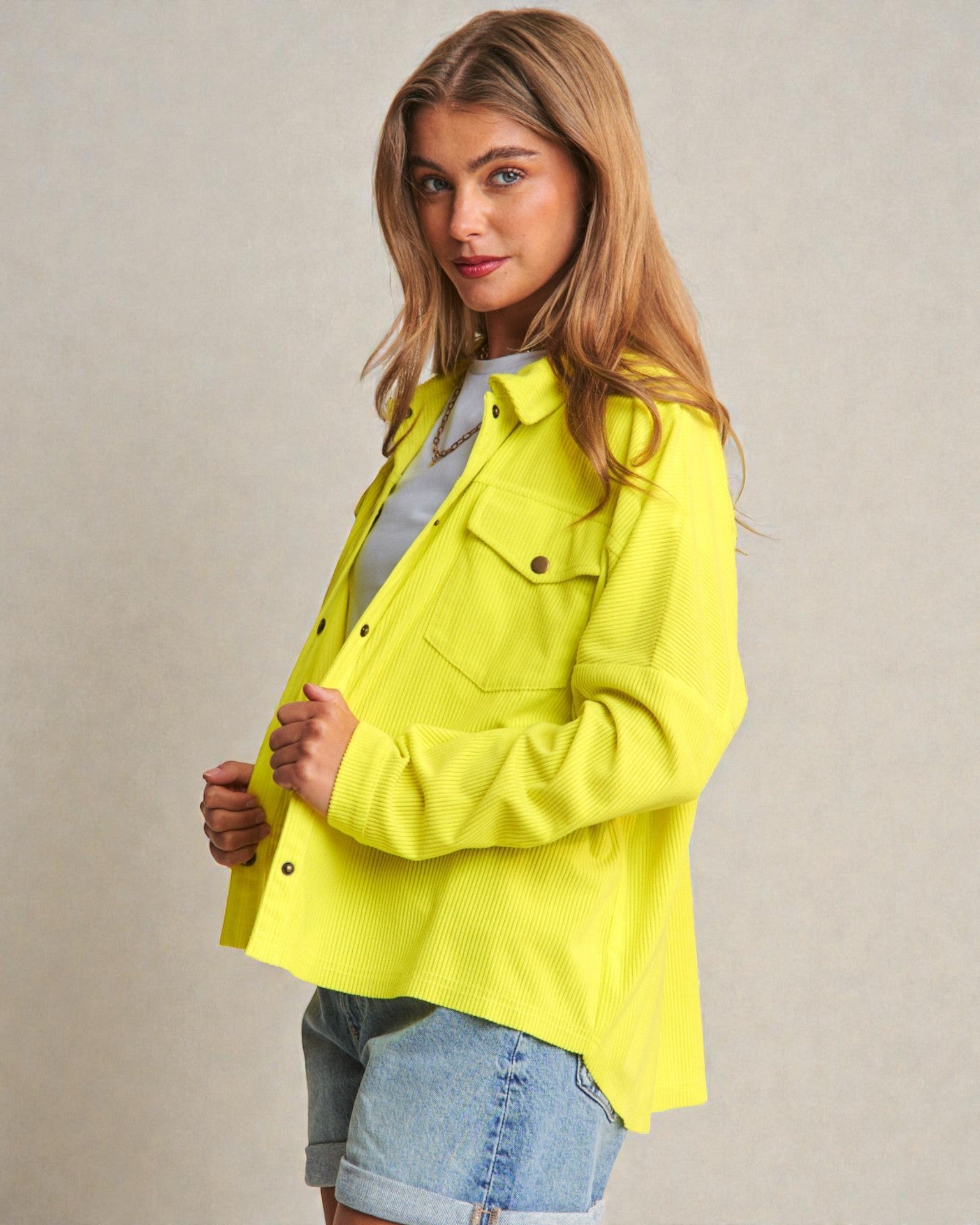 Woman wearing a bright yellow jacket against a plain background