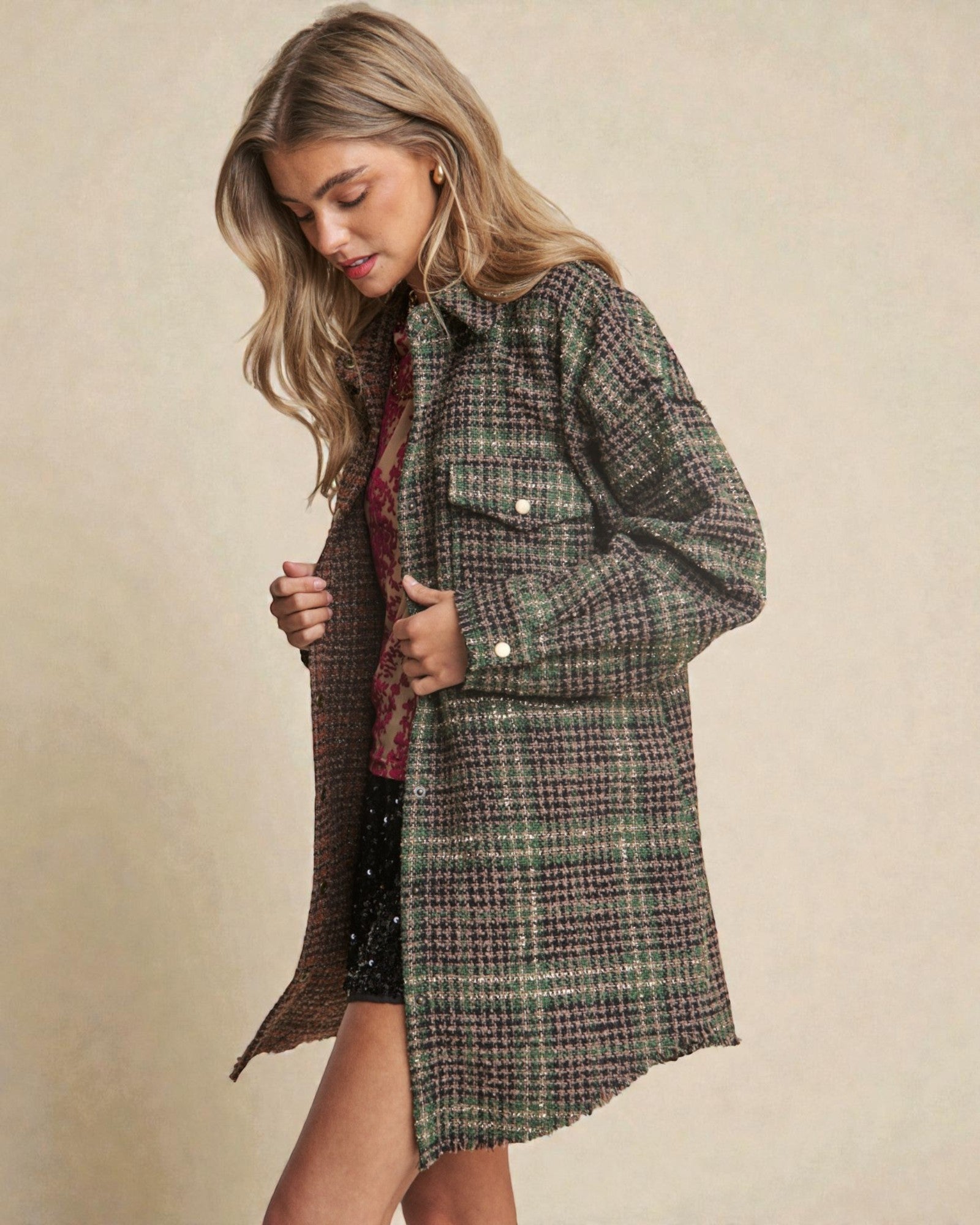 Woman wearing a plaid coat against a beige background