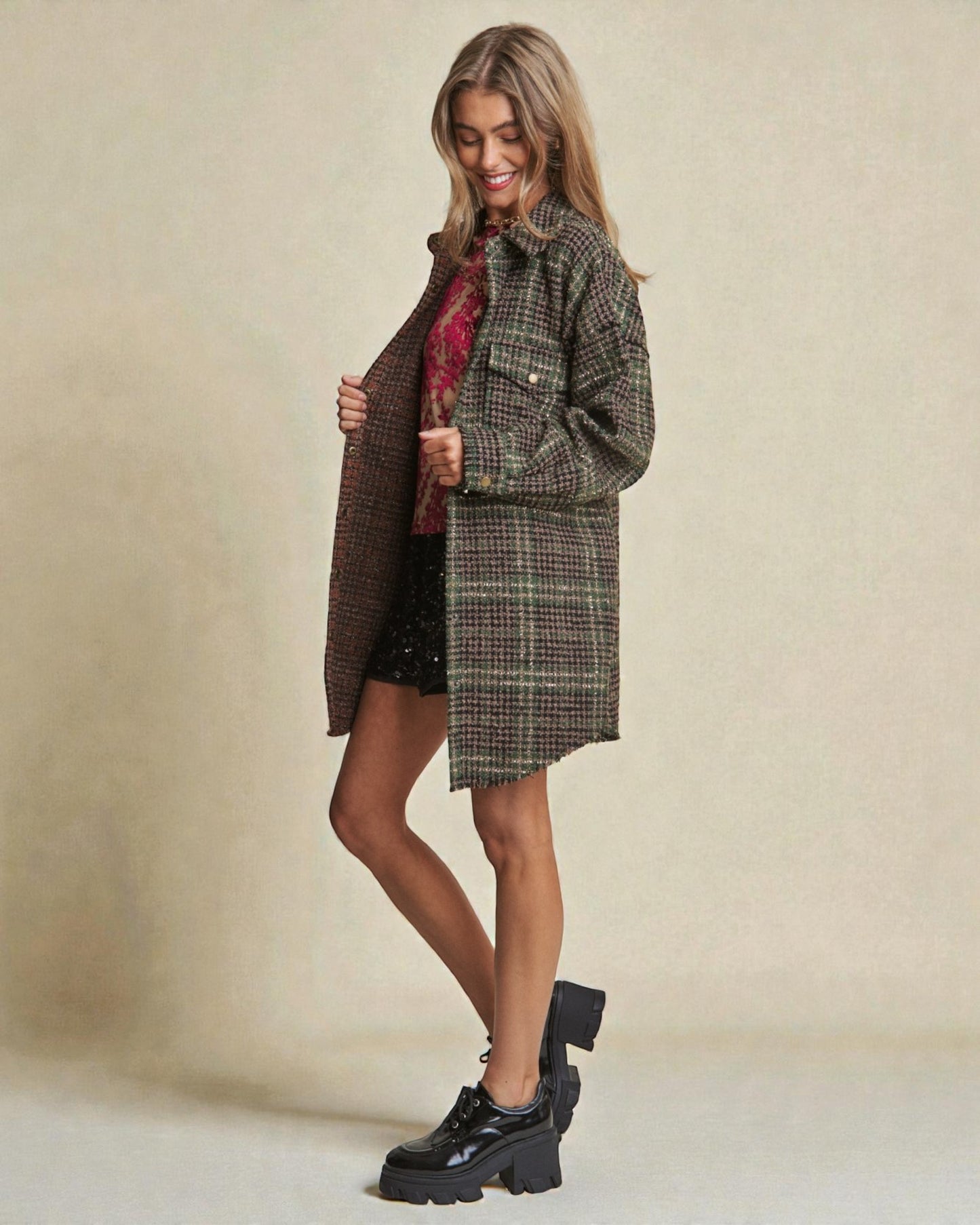 Woman wearing a plaid coat and skirt with black shoes on a beige background