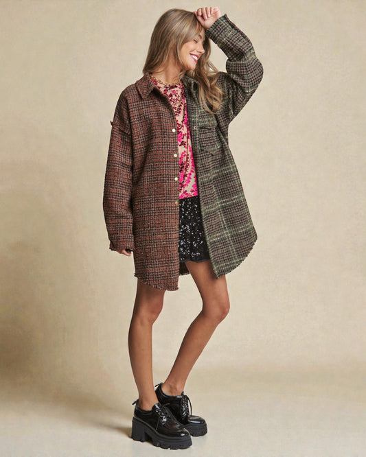 Woman wearing a plaid coat over a floral dress with a beige background