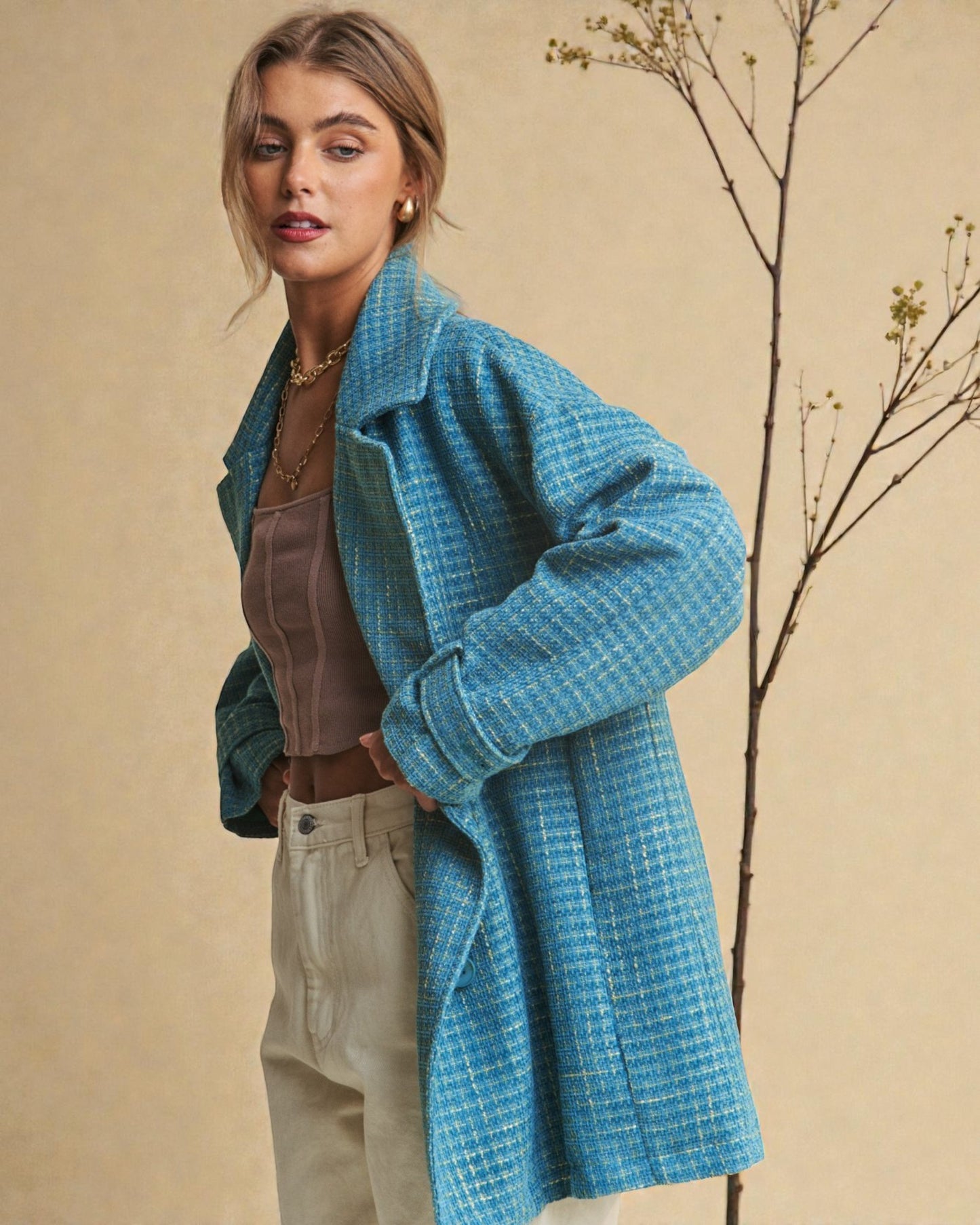 Woman wearing a blue checkered coat against a beige background