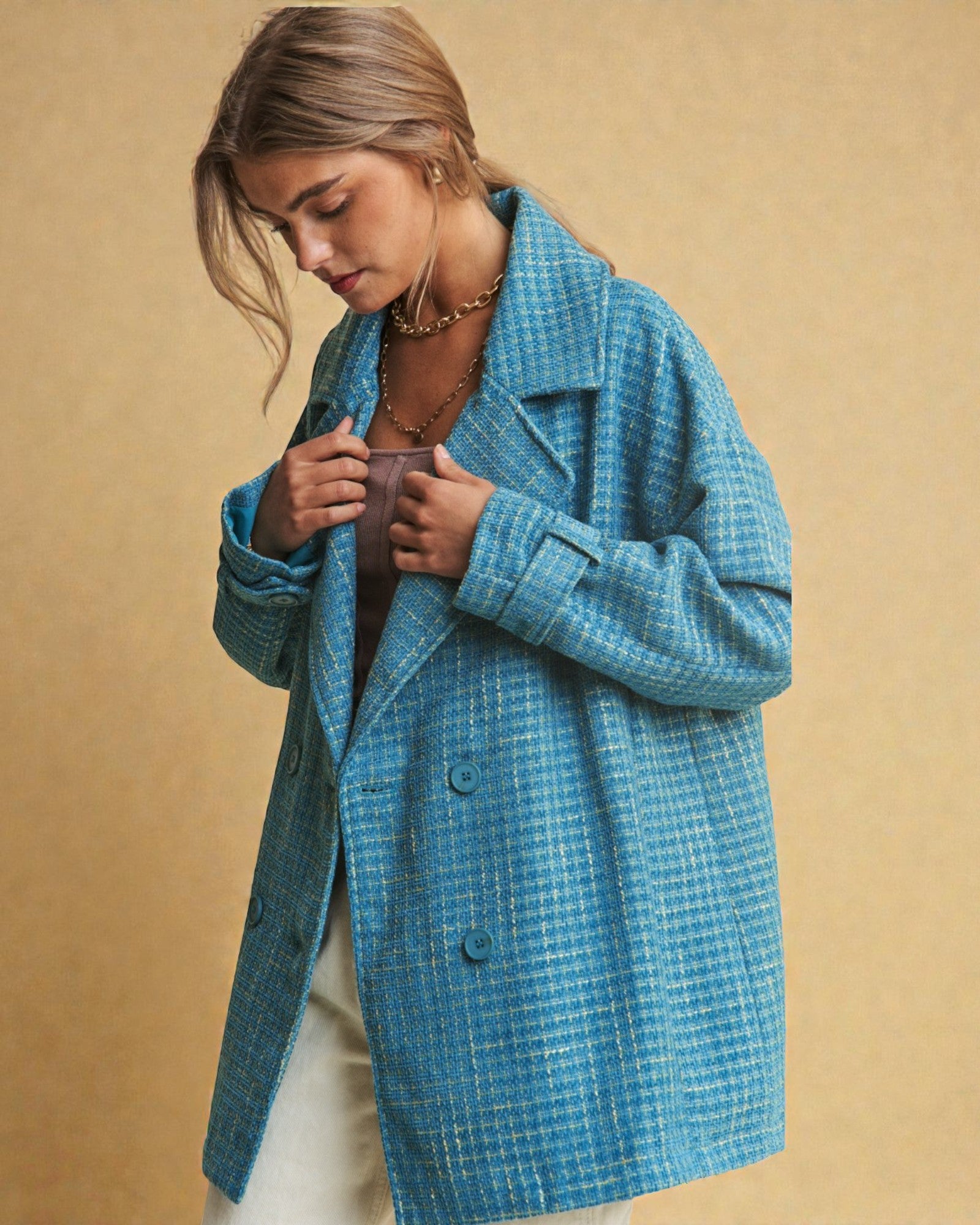 Woman wearing a blue checkered coat against a beige background