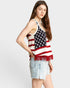 Woman wearing a tank top with an American flag design on a plain background
