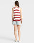 Person wearing a red and white striped tank top and denim shorts on a light gray background