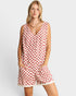 Woman wearing a red and white checkered romper on a light gray background