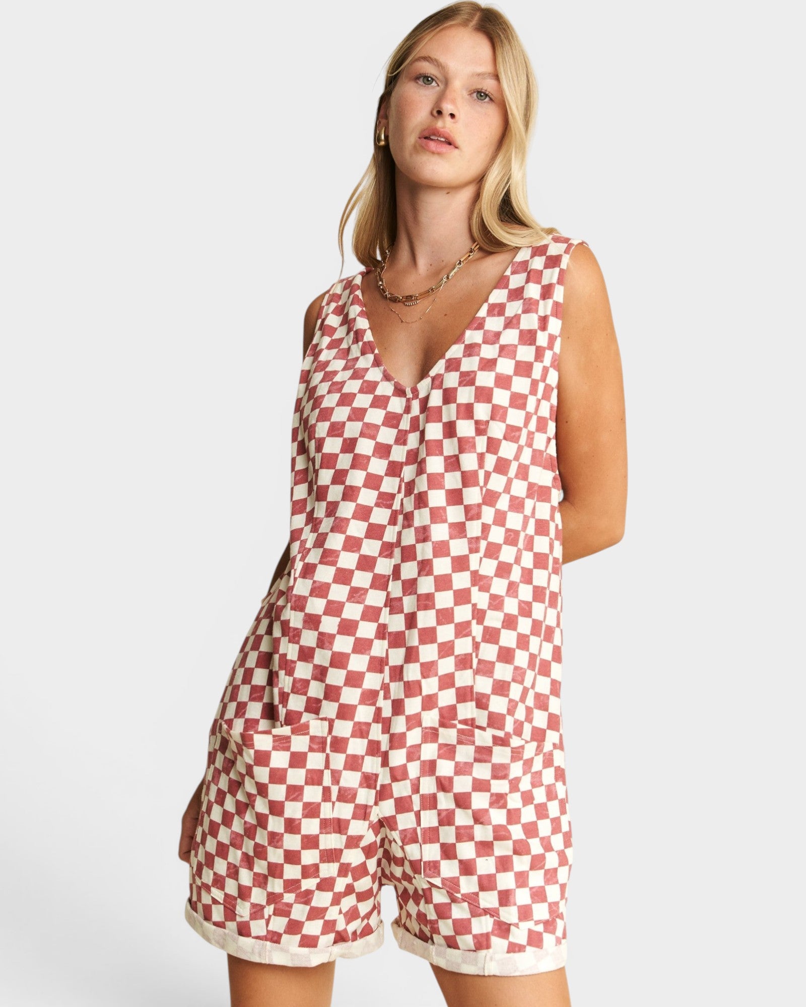 Woman wearing a red and white checkered romper on a white background