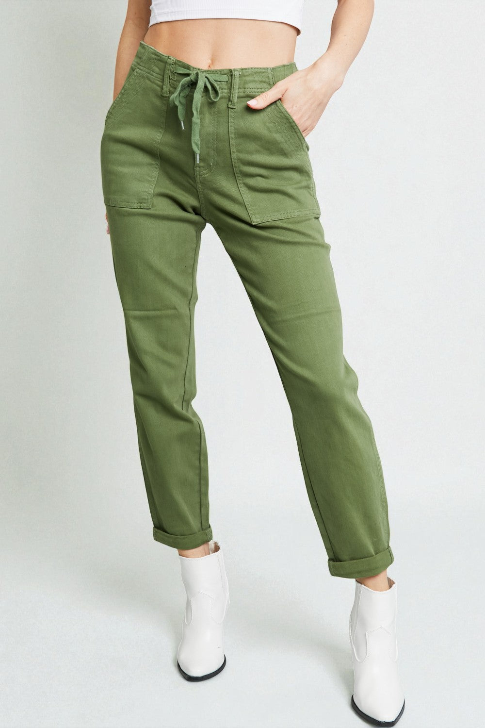 Person wearing green pants with a white background
