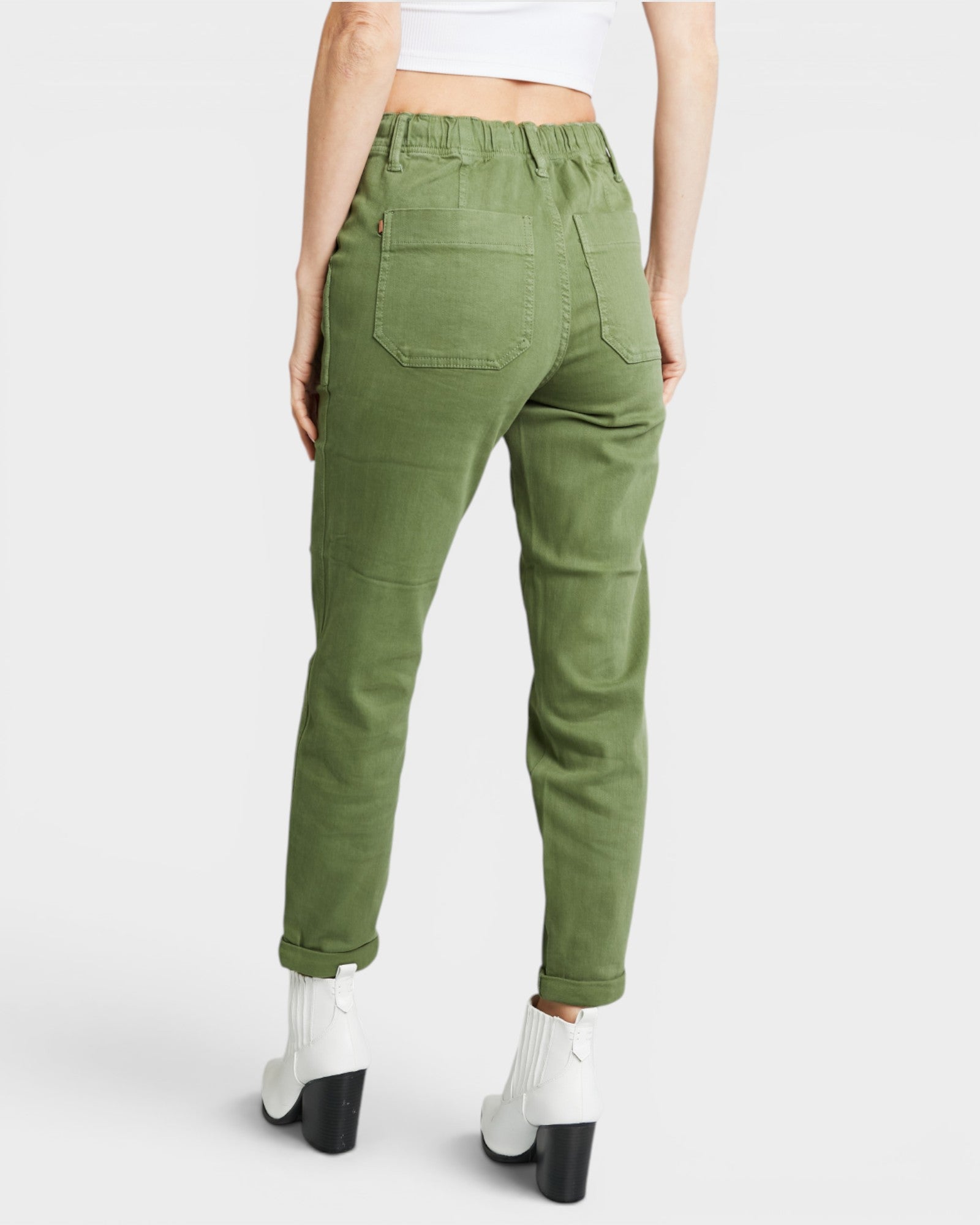 Green pants worn by a person on a white background
