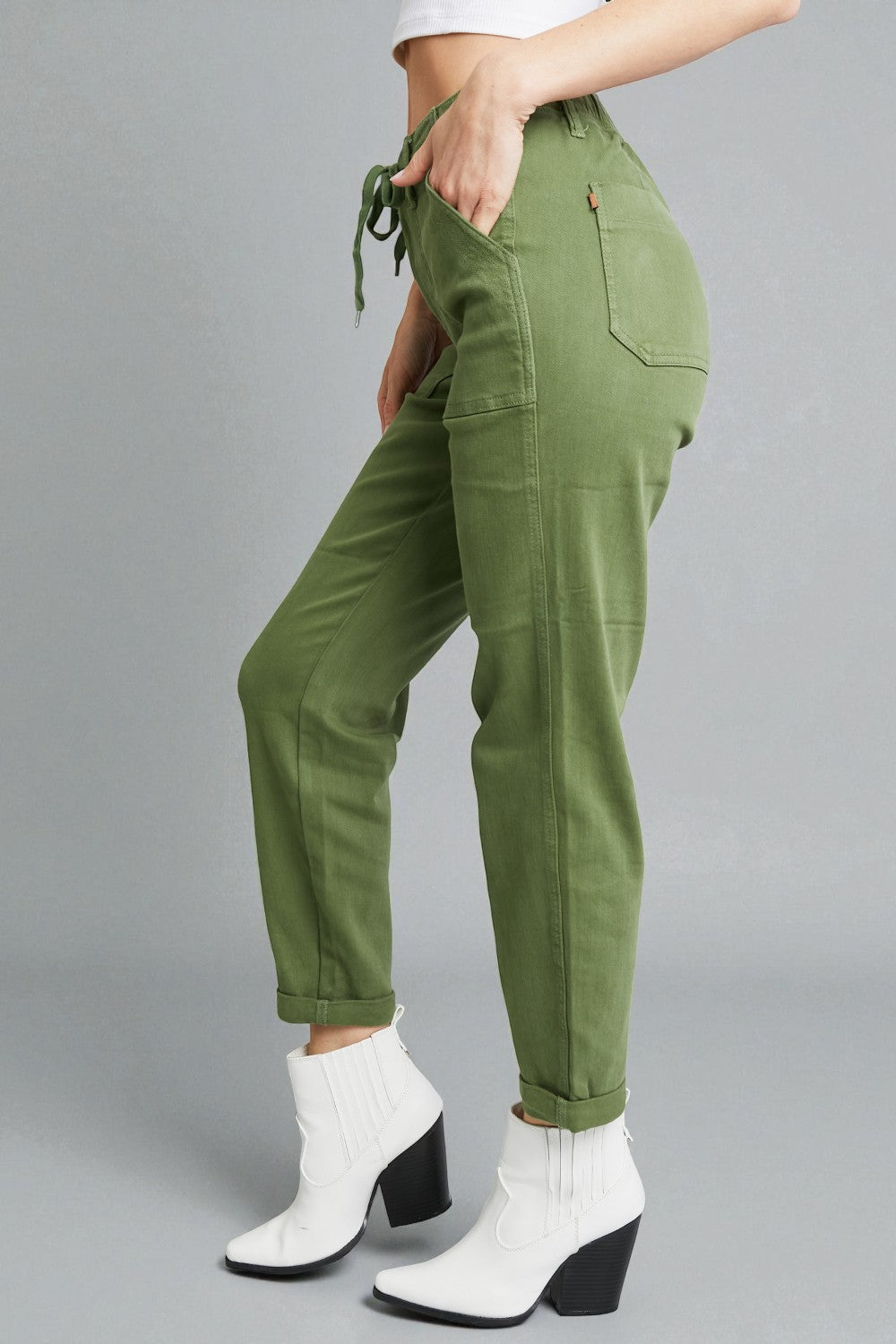 Green pants worn by a person on a gray background