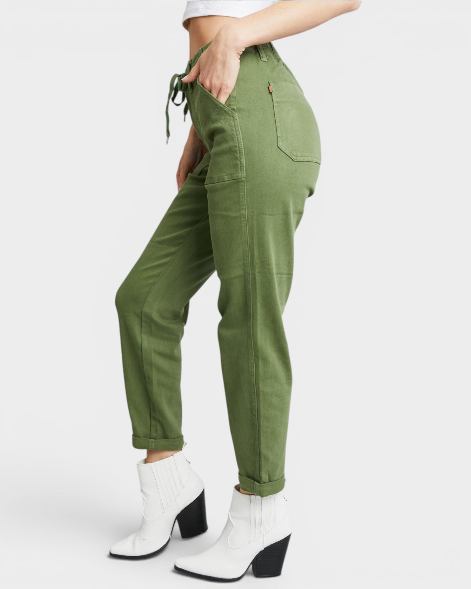 Green cargo pants worn by a person on a white background
