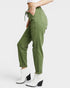 Green cargo pants worn by a person on a white background