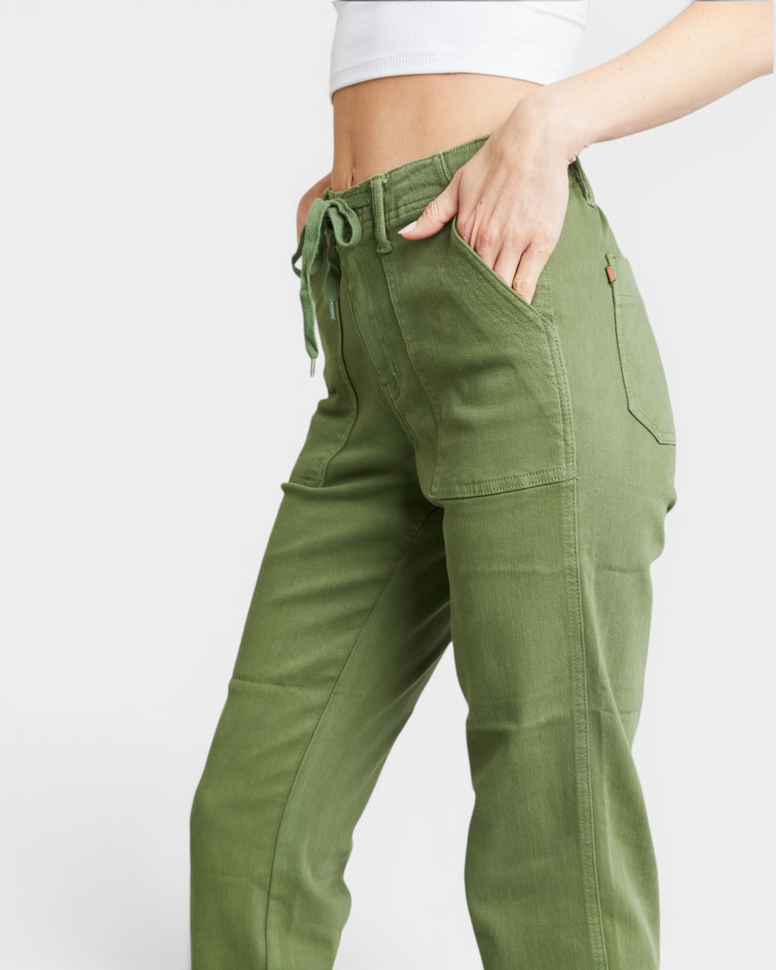 Green cargo pants worn by a person on a white background