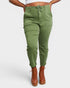 Person wearing green pants and brown boots on a white background