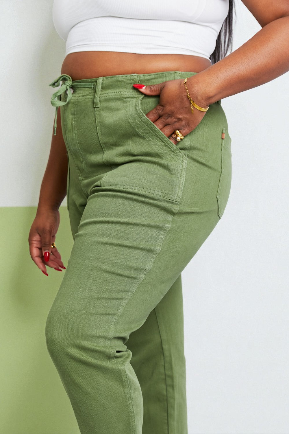 Person wearing green pants with a white background