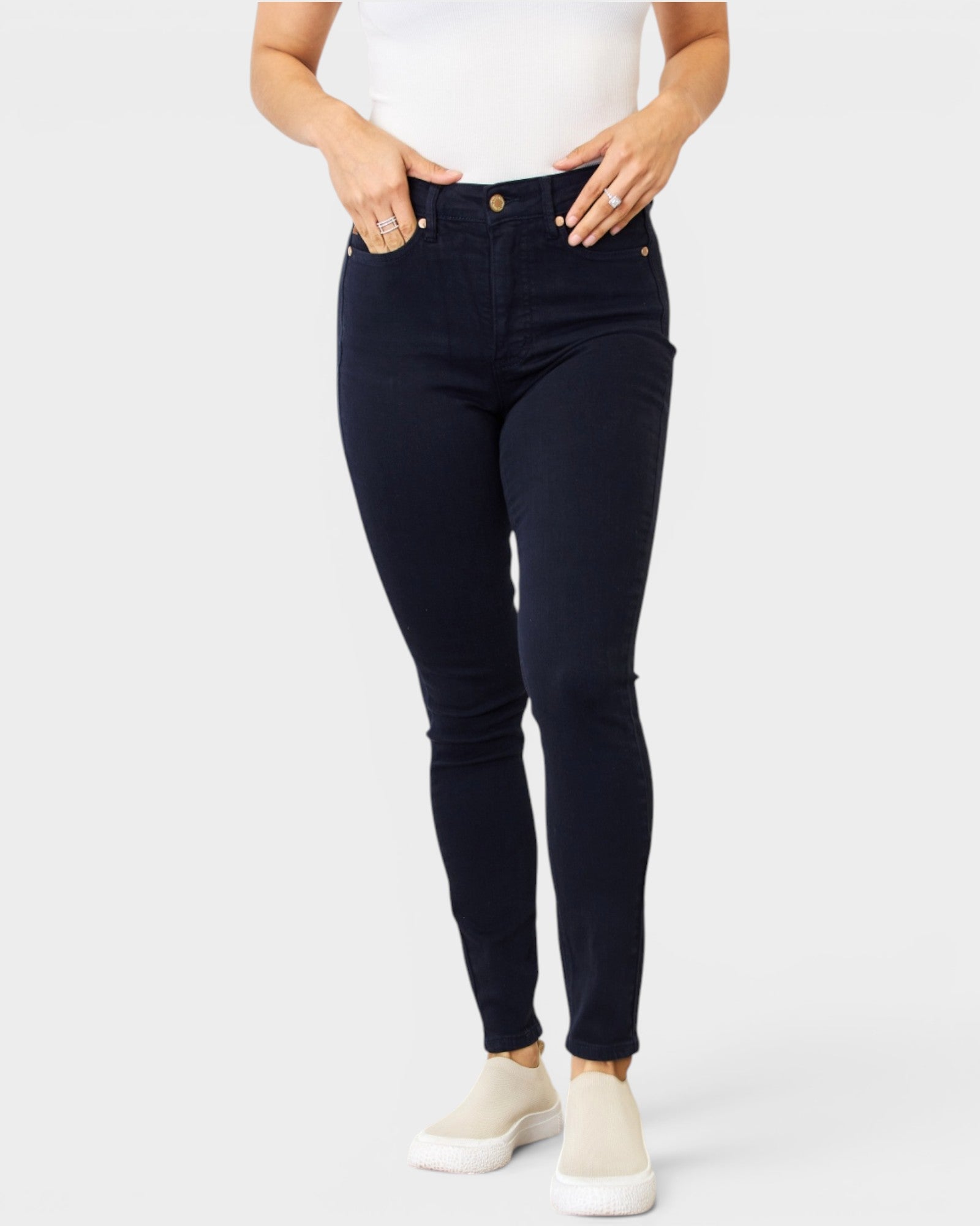 Person wearing dark blue jeans on a white background