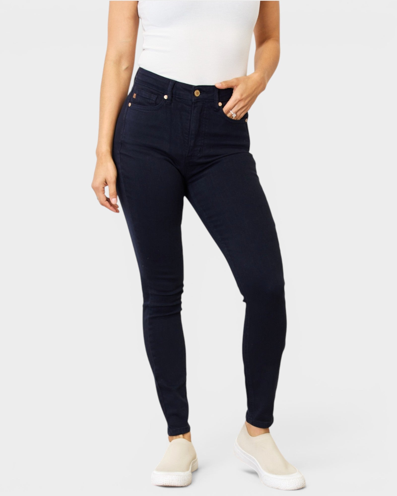 Person wearing dark blue jeans on a white background