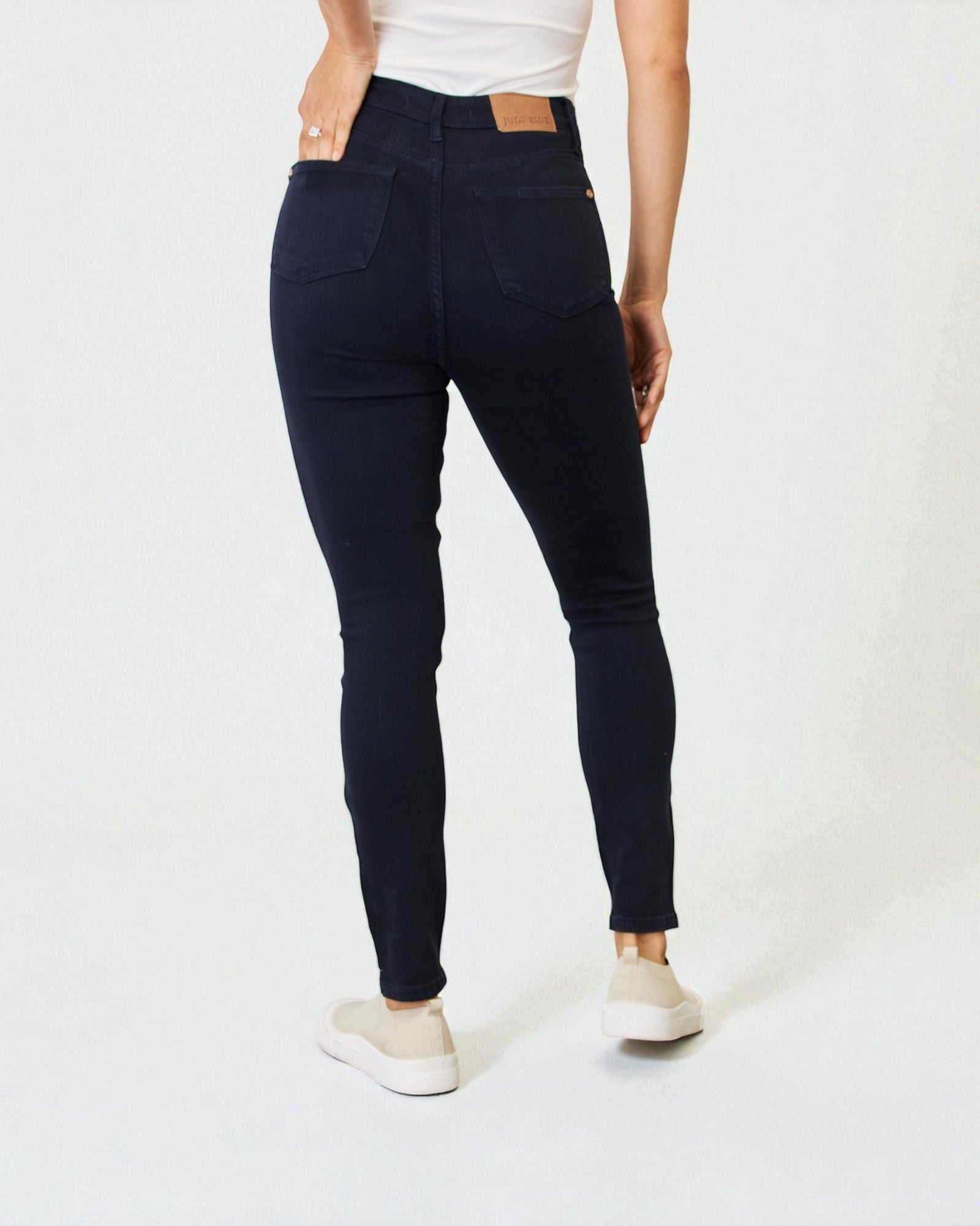 Person wearing black jeans on a white background