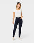 Woman wearing navy blue jeans and a white top on a white background