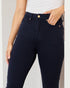 Person wearing navy blue jeans with a white background