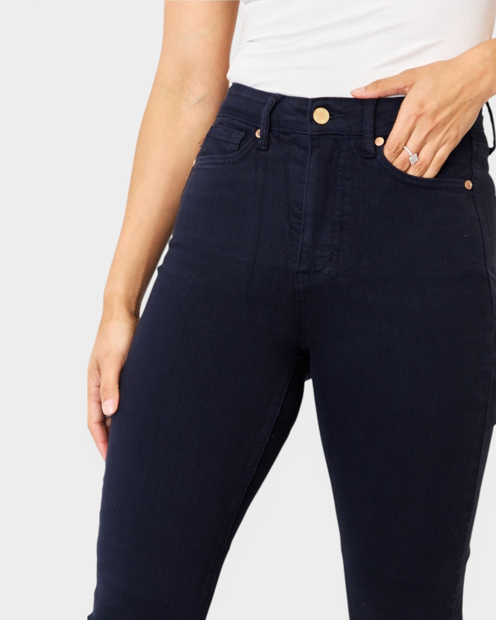 Navy blue jeans worn by a person on a light gray background