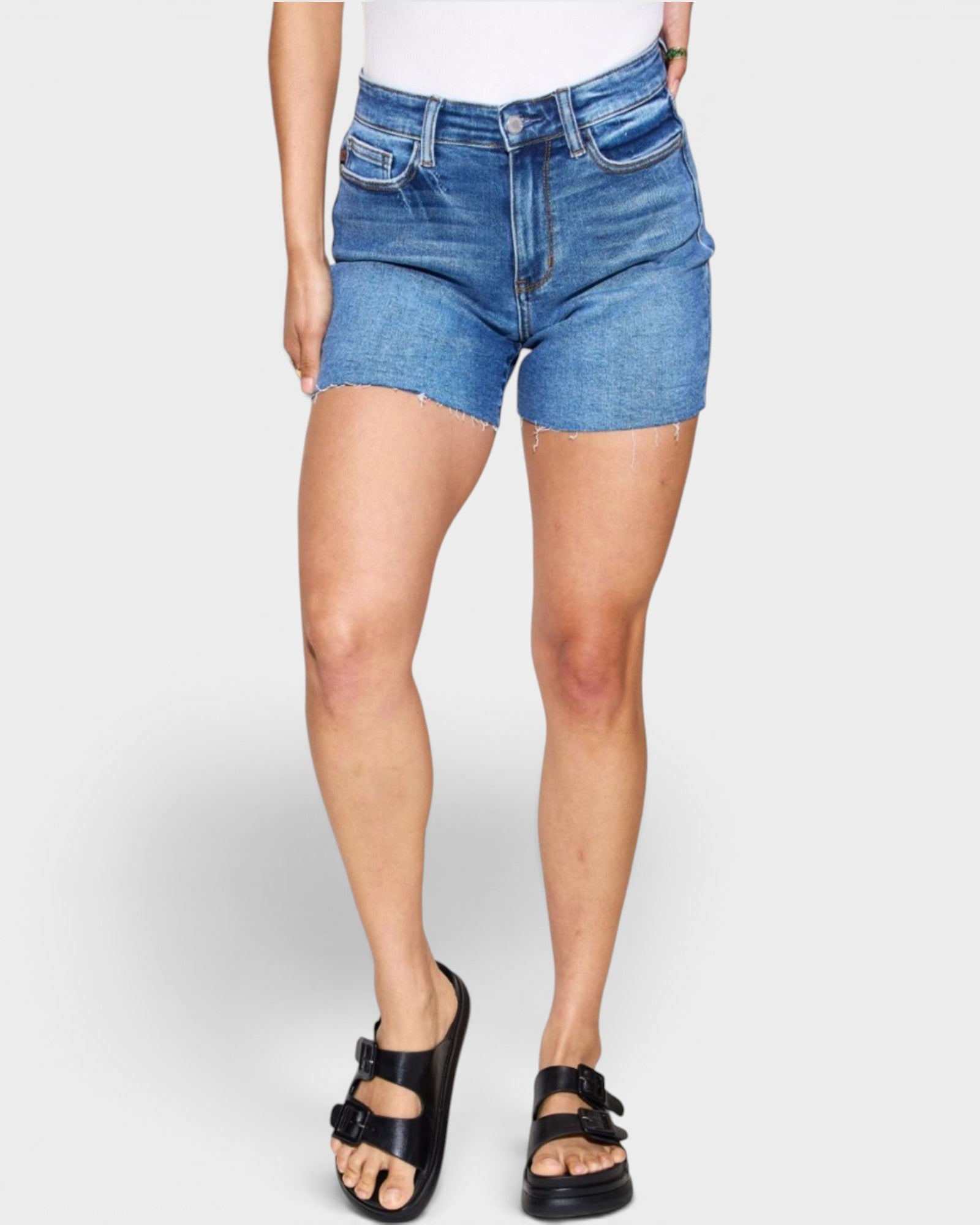 Person wearing blue denim shorts on a white background