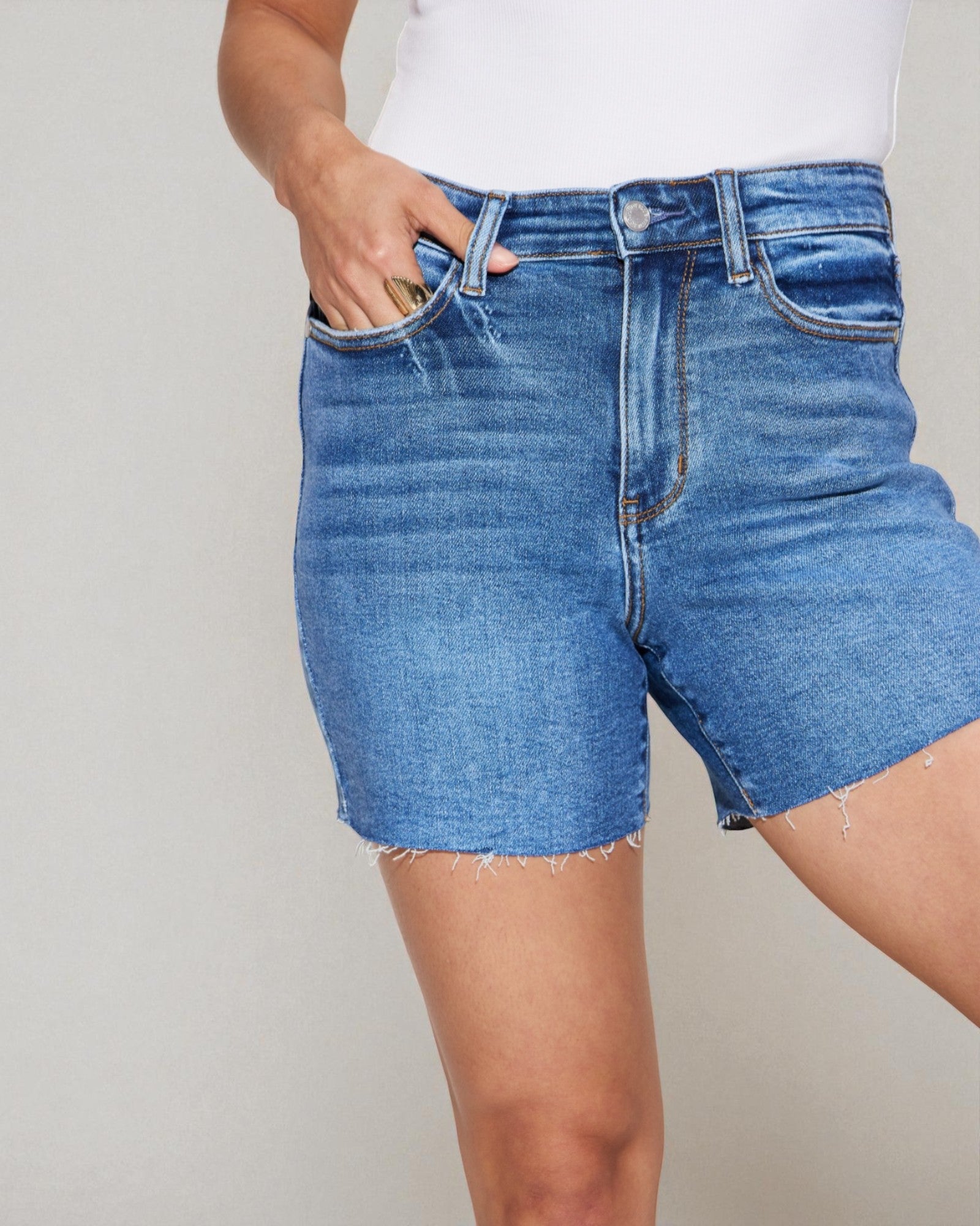 Person wearing blue denim shorts on a plain background