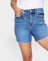 Blue denim shorts worn by a person on a white background