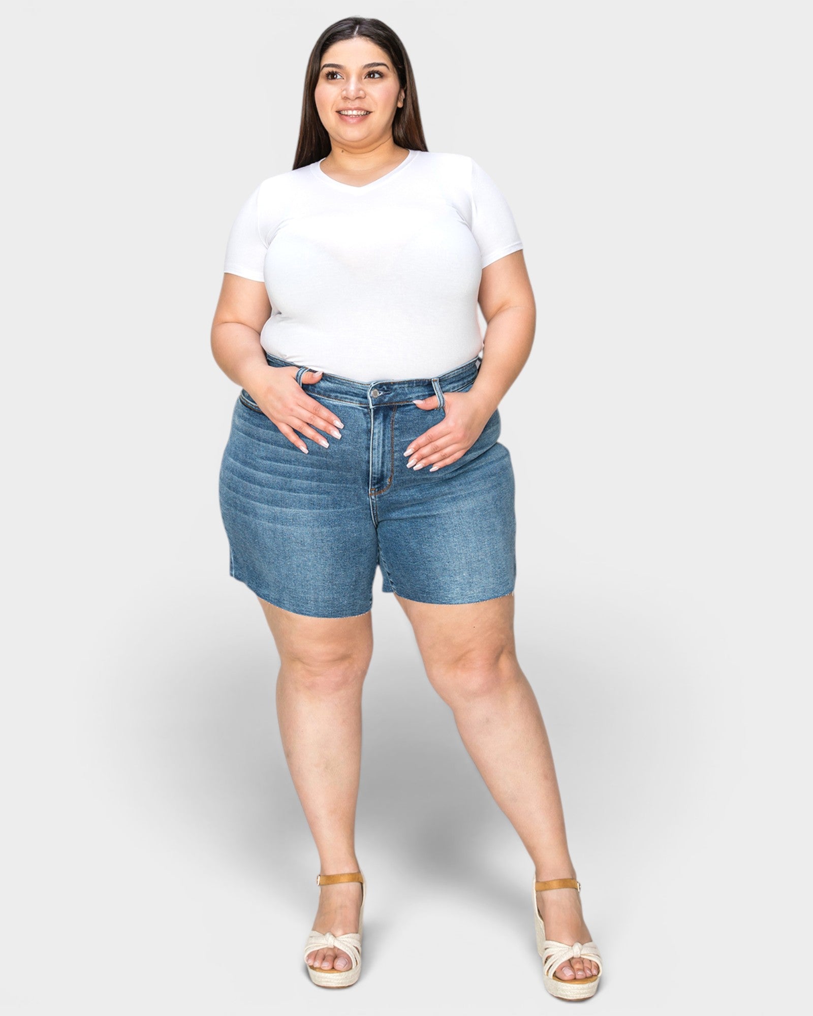 Woman wearing a white t-shirt and blue denim shorts on a white background