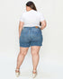 Person wearing blue denim shorts and a white t-shirt on a plain background