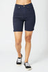 Navy blue denim shorts worn by a person on a white background