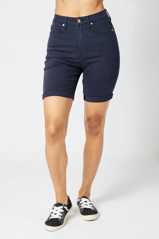 Person wearing navy blue shorts on a white background