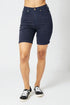 Person wearing navy blue shorts on a white background