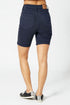 Navy blue shorts worn by a person on a white background