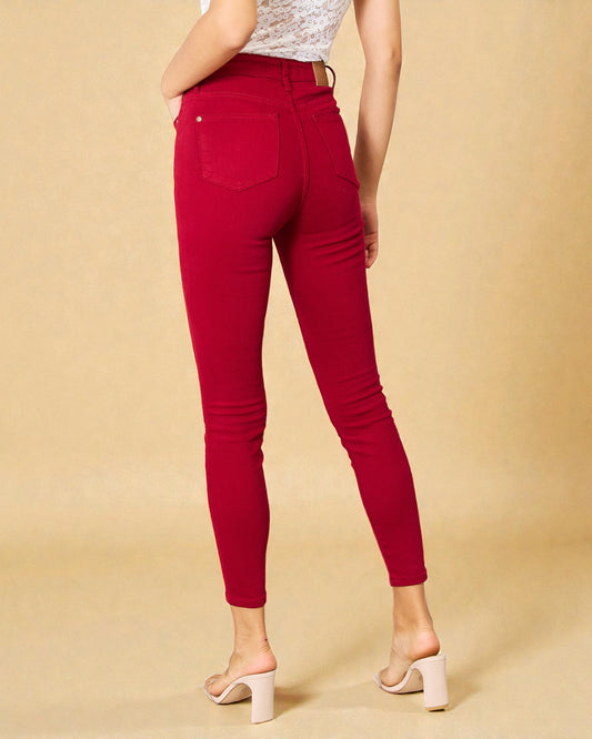 Red jeans worn by a person on a beige background