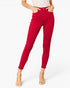 A model wearing bright red skinny ankle-length jeans with a white lace top and clear high-heeled sandals, shown against a plain white studio background.