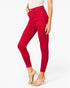 A model wearing bright red high-waisted skinny ankle pants with a white lace top and clear high-heeled sandals, shown against a plain white studio background.