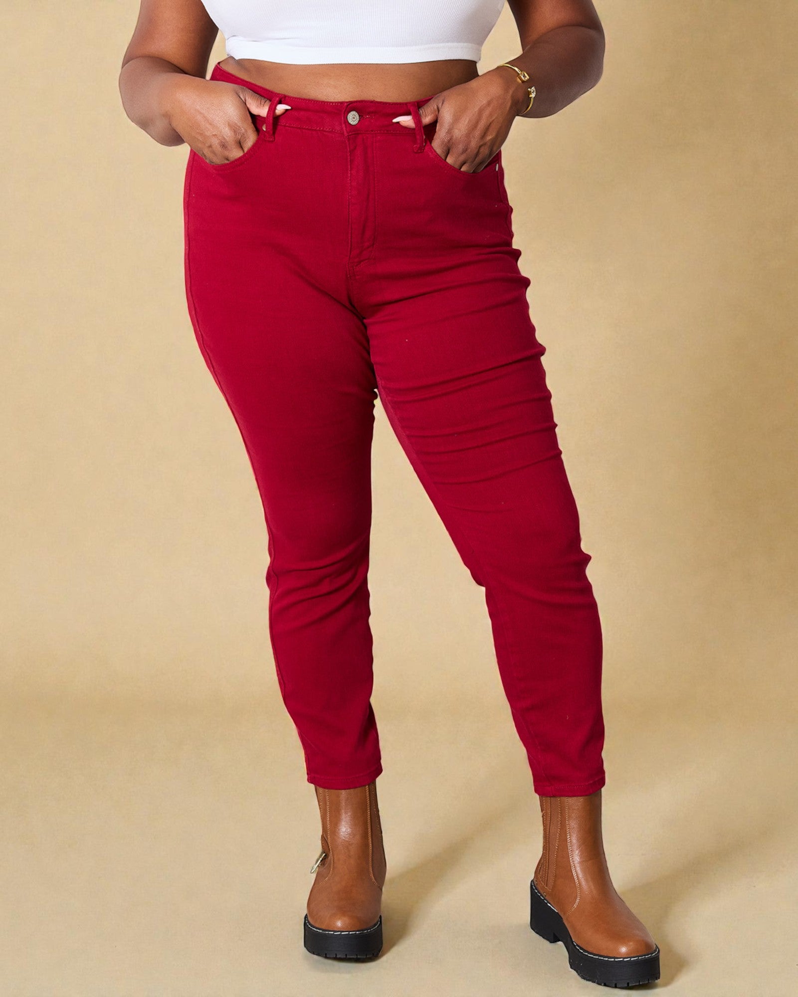 Person wearing red pants and brown shoes on a beige background