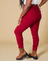 Person wearing red pants and brown boots on a beige background