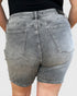 Gray denim shorts worn by a person on a plain background