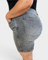 Person wearing gray denim shorts on a plain background