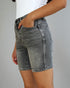 Person wearing gray denim shorts on a plain background