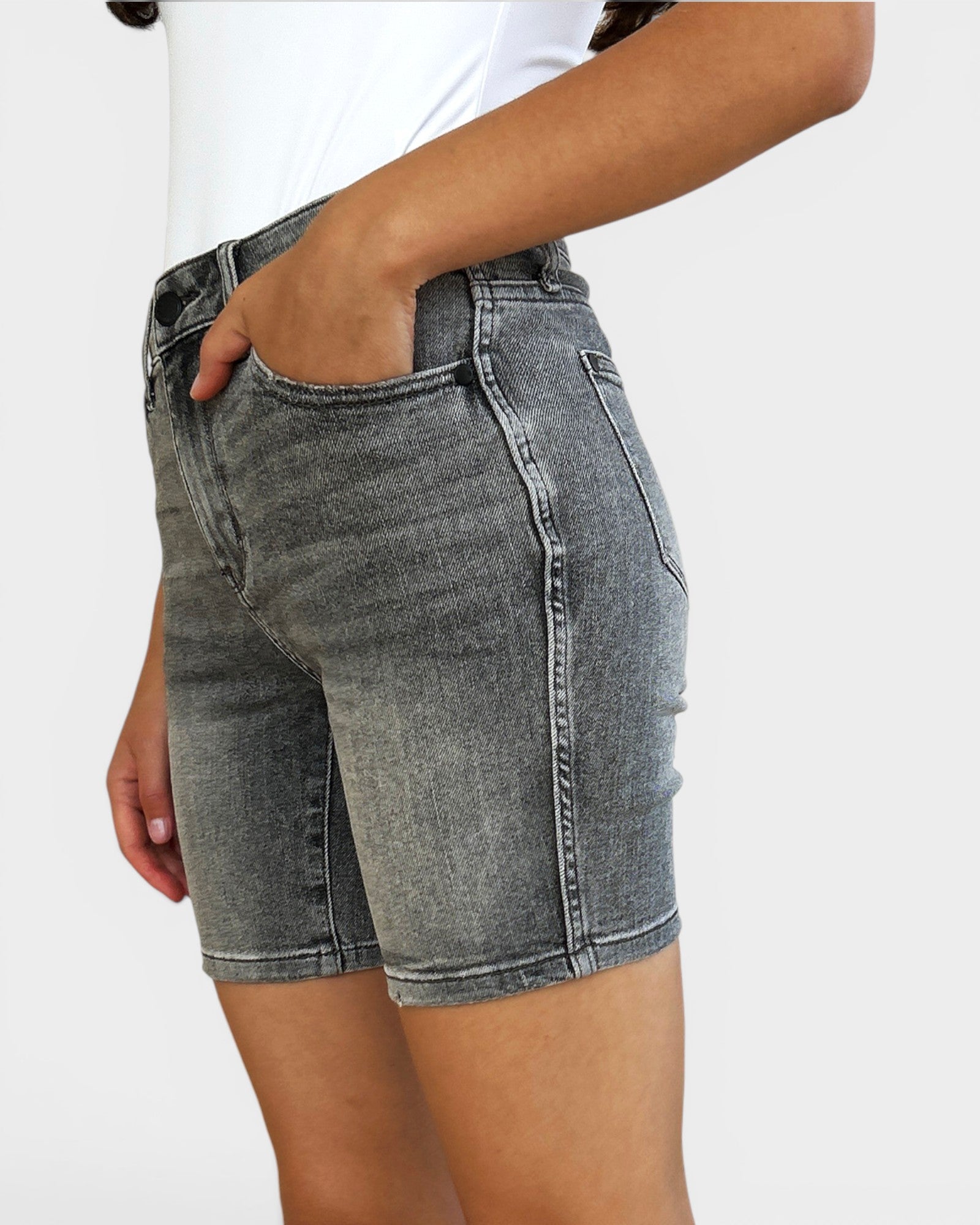 Gray denim shorts worn by a person on a white background