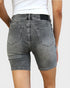 Person wearing gray denim shorts on a plain background