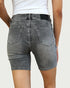 Person wearing gray denim shorts on a plain background