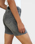 Person wearing gray denim shorts on a plain background