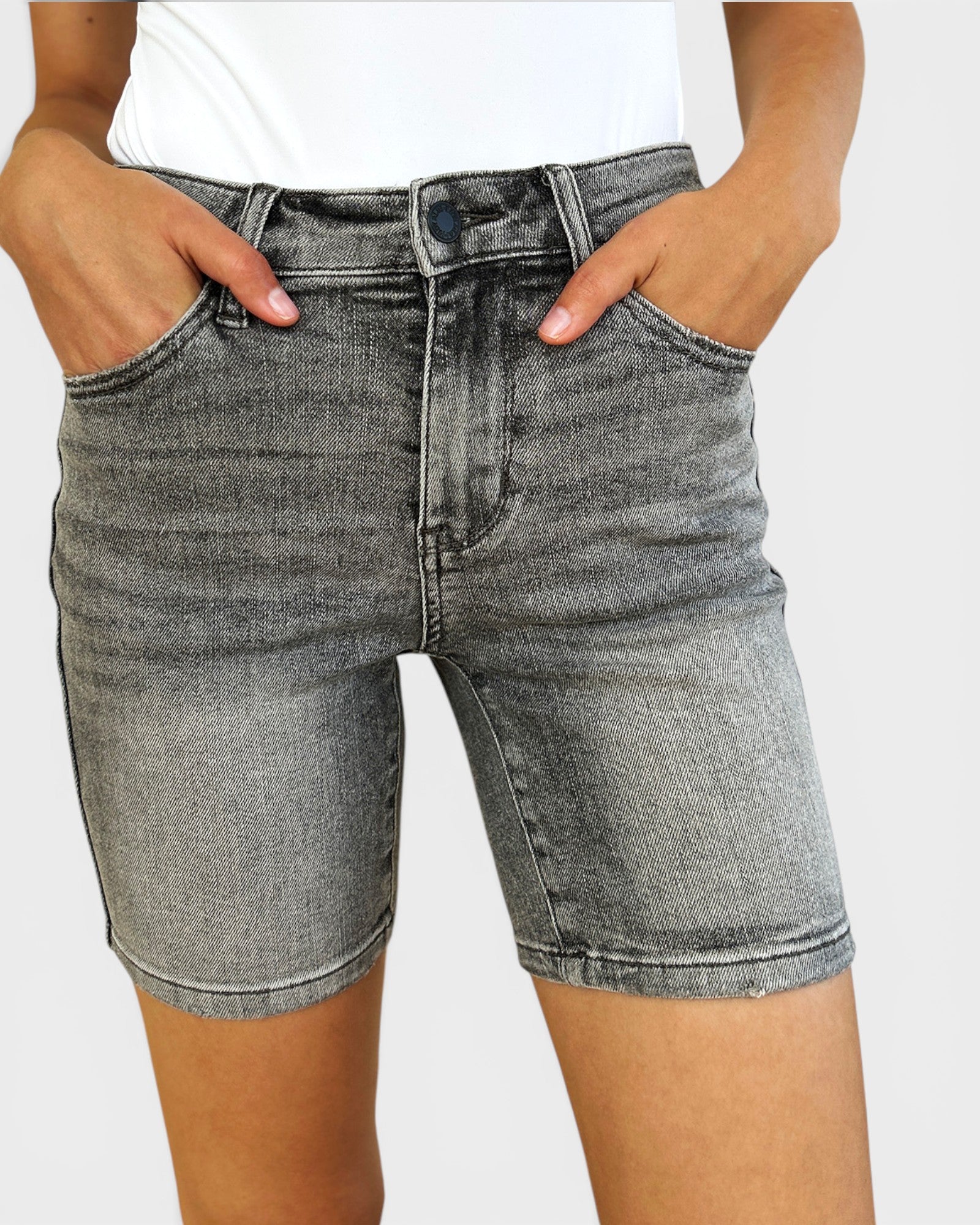 Person wearing gray denim shorts on a plain background