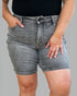 Person wearing gray denim shorts on a gray background