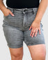 Person wearing gray denim shorts on a plain background