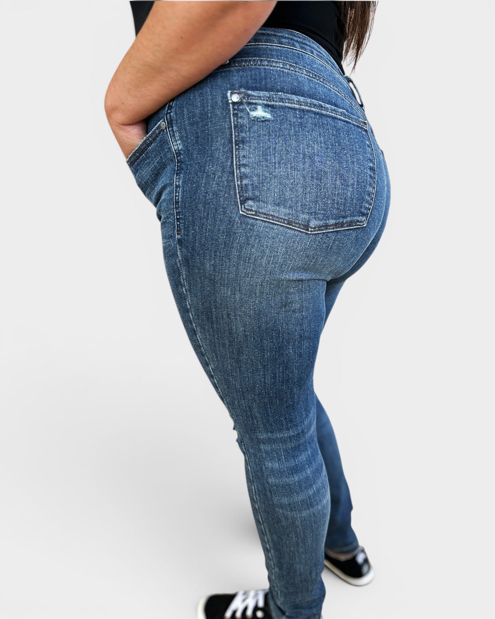 Blue jeans worn by a person on a white background